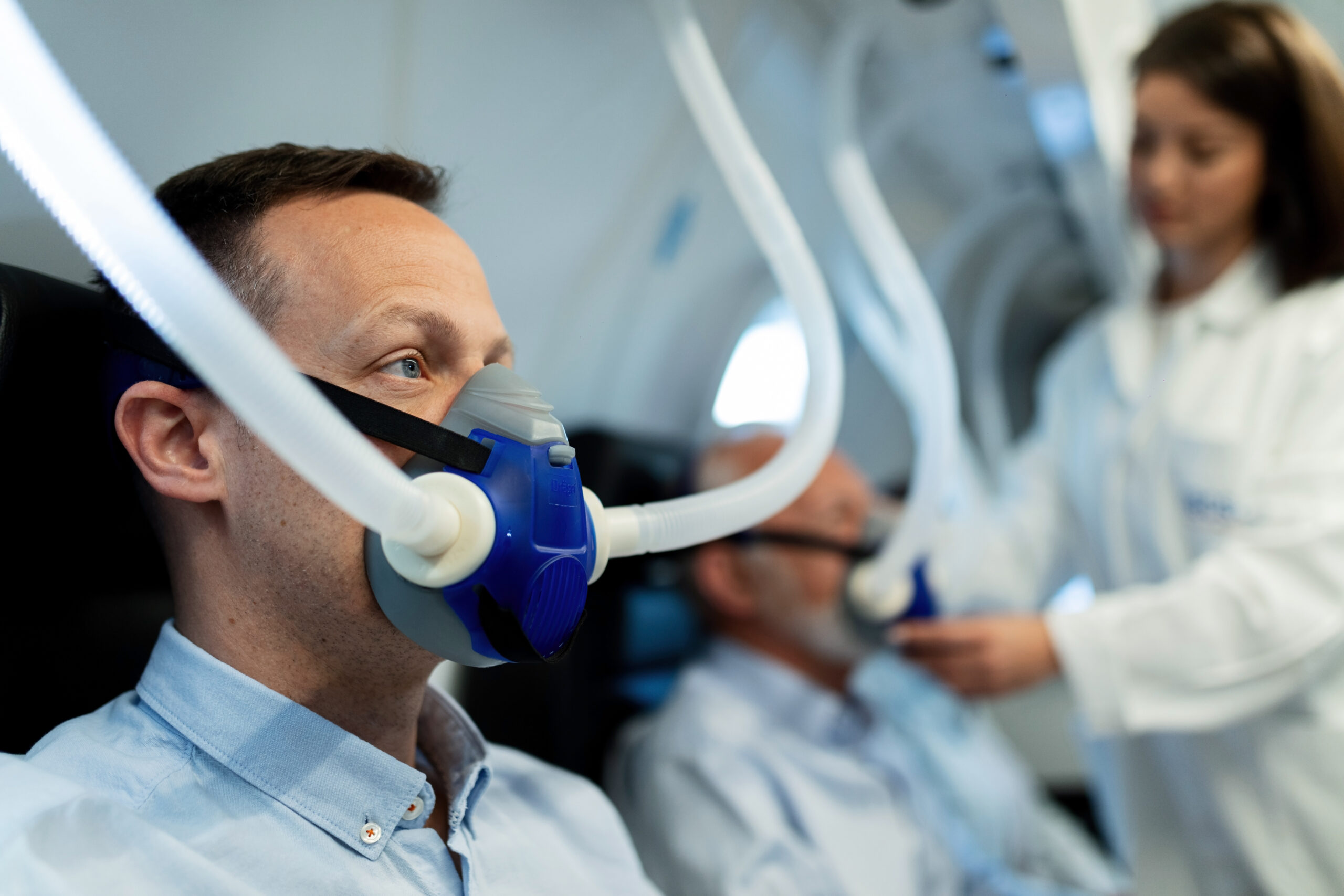 Mid adult man breathing through mask during hyperbaric oxygen therapy at clinic.